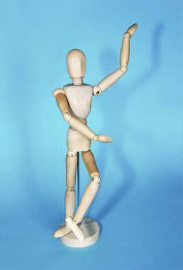 sarı ahşap maniken dans ve mavi arka plan üzerinde pozlar yapıyor
