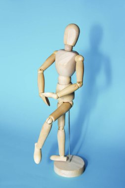 sarı ahşap maniken dans ve mavi arka plan üzerinde pozlar yapıyor
