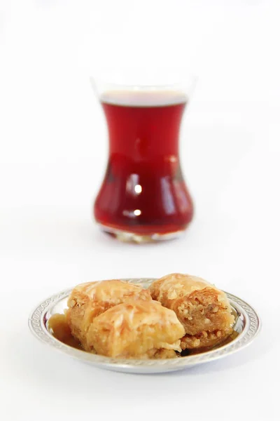 Baklava dulce nacional tradicional turco en plato decorativo y un vaso de té — Foto de Stock