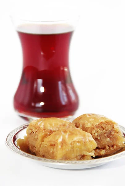 Baklava dulce nacional tradicional turco en plato decorativo y un vaso de té — Foto de Stock