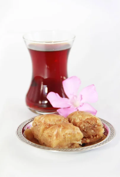 Baklava dulce nacional tradicional turco en plato decorativo y un vaso de té — Foto de Stock