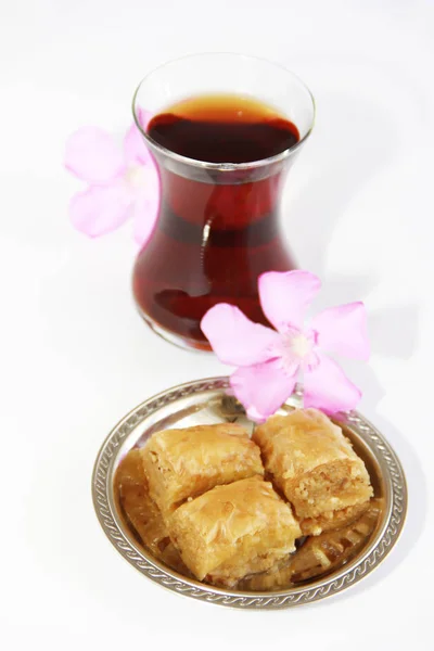 Baklava dulce nacional tradicional turco en plato decorativo y un vaso de té — Foto de Stock