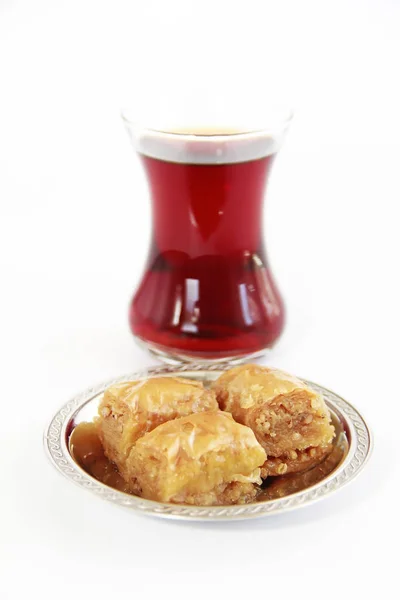 Baklava dulce nacional tradicional turco en plato decorativo y un vaso de té — Foto de Stock