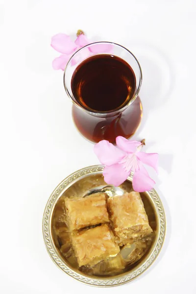 Baklava dulce nacional tradicional turco en plato decorativo y un vaso de té — Foto de Stock