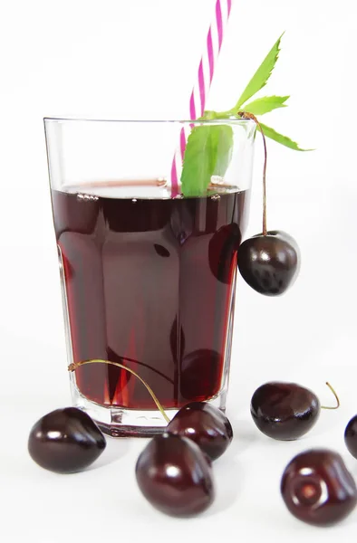 Cherry berry and glass with fruit juice with mint leaves — Stock Photo, Image