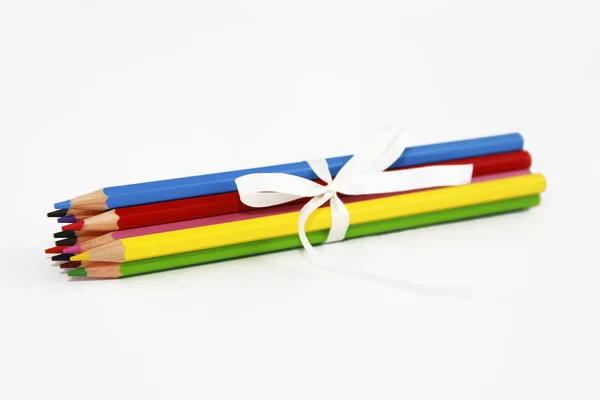 五颜六色的木制铅笔,用于在白色背景上用白色蝴蝶结绘图 — 图库照片