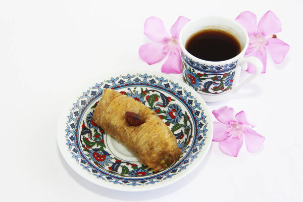 Eastern Turkish traditional sweet baklava on colorful plate and a cup of coffee