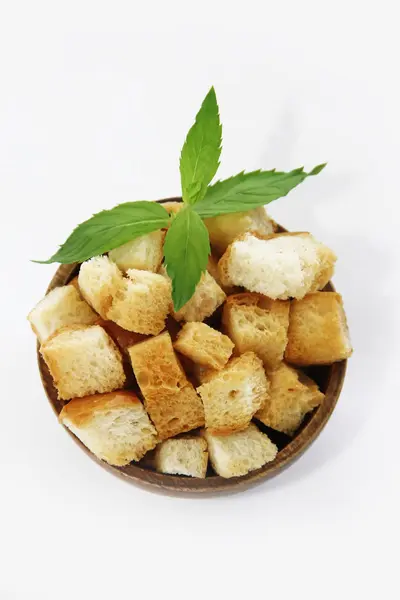 Fried white bread croutons with mint leaves in wooden plate — Stock Image Fried white bread croutons with mint leaves in wooden plate Stock Image