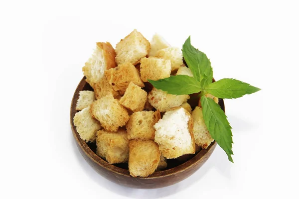 Fried white bread croutons with mint leaves in wooden plate — Stock Image Fried white bread croutons with mint leaves in wooden plate Stock Photo