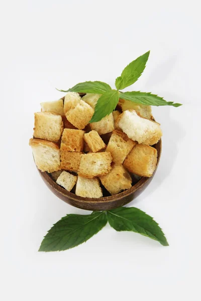 Fried white bread croutons with mint leaves in wooden plate — Stock Image Fried white bread croutons with mint leaves in wooden plate Stock Image