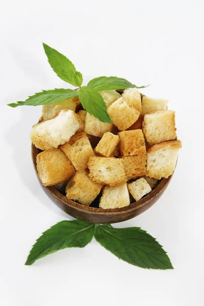 Fried white bread croutons with mint leaves in wooden plate — Stock Image Fried white bread croutons with mint leaves in wooden plate Stock Image