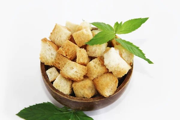 Fried white bread croutons with mint leaves in wooden plate — Stock Image Fried white bread croutons with mint leaves in wooden plate Stock Photo