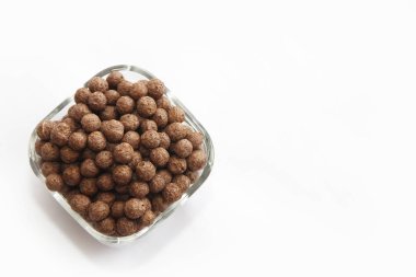 beyaz bir arka plan üzerinde cam bir tabak tatlı mısır çikolata topları