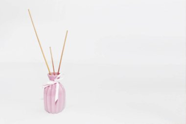 seramik pembe vazo içinde aromaterapi için ahşap çubuklar