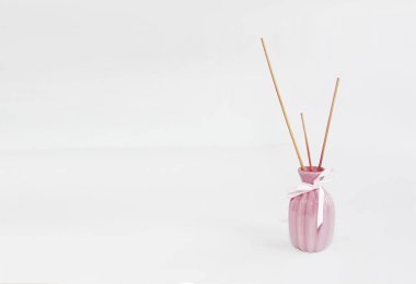 seramik pembe vazo içinde aromaterapi için ahşap çubuklar