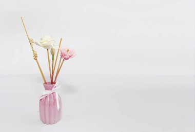 seramik pembe vazo içinde aromaterapi için ahşap çubuklar