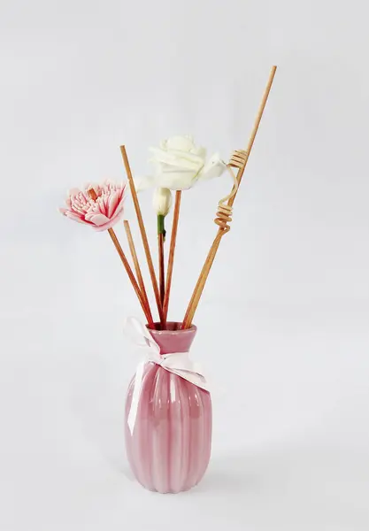 Varillas de madera para aromaterapia en un jarrón rosa cerámico — Foto de Stock