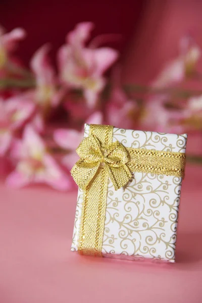 Białe pudełko z złotą kokardą i wzorami — Zdjęcie stockowe