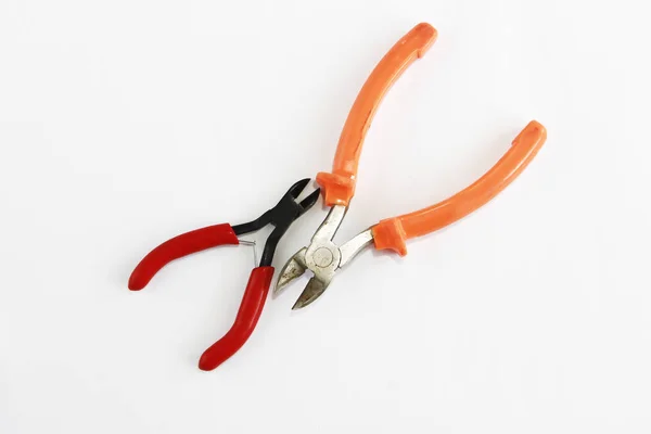 Two metal old rusty pliers with red and orange handle — Stock Photo, Image