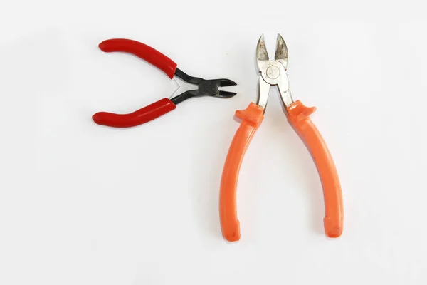 Два металлических ржавых плоскогубца с красной и оранжевой ручкой — стоковое фото