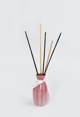seramik pembe vazo içinde aromaterapi için ahşap çubuklar