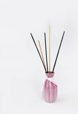 seramik pembe vazo içinde aromaterapi için ahşap çubuklar