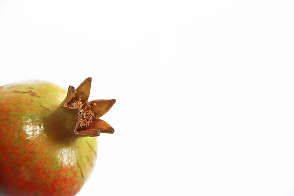 Frutos de una granada verde anaranjada natural inmadura sobre un fondo blanco —  Fotos de Stock