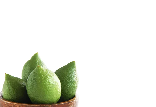 Früchte der grünen natürlichen Zitrone in einem hölzernen braunen Teller — Stockfoto