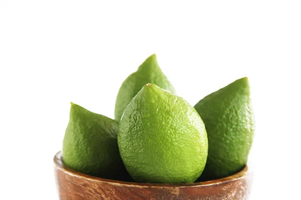 Fruits of green natural lime lemon in a wooden brown a plate — Stock Photo, Image