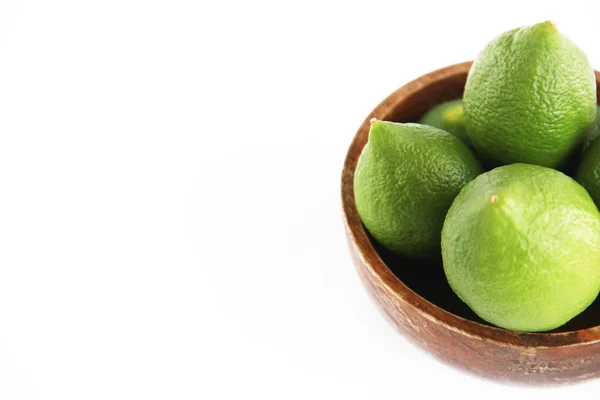 Φρούτα από πράσινο φυσικό λεμόνι λάιμ σε ένα ξύλινο καφέ ένα πιάτο — Φωτογραφία Αρχείου