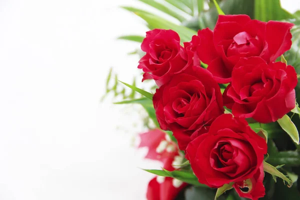 Dekoratives Bouquet aus roten natürlichen Rosen mit grünen Blättern — Stockfoto