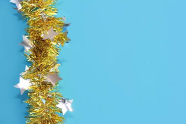 yeni yıl tatili için mavi arka plan üzerinde sarı parlak noel tinsel