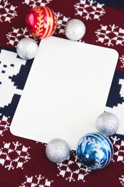 Feestelijke textuur van wollen gebreide stof rood en blauw met New Year's decor sneeuwpop en kerstballen — Stockfoto