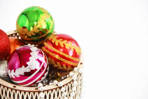 Brilhantes bolas de Natal multi-coloridas brinquedos em uma cesta de madeira decorativa para o feriado de Ano Novo — Fotografia de Stock