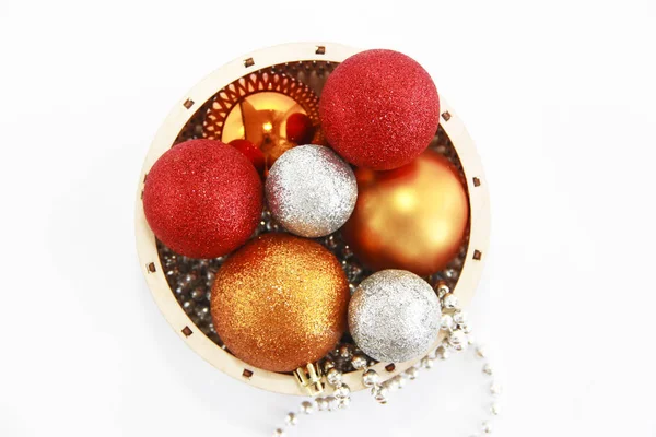 Brilhantes bolas de Natal multi-coloridas brinquedos em uma cesta de madeira decorativa para o feriado de Ano Novo — Fotografia de Stock