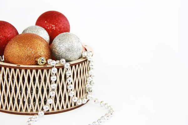 Λαμπερό πολύχρωμο Χριστουγεννιάτικα μπαλάκια παιχνίδια σε ένα διακοσμητικό ξύλινο καλάθι για το νέο έτος διακοπών — Φωτογραφία Αρχείου