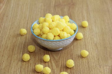 Kahvaltı için seramik tabakta yuvarlak sarı doğal mısır topları.