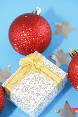 Noel çok renkli kırmızı toplar ağaç süslemeleri ve yeni yıl için sarı kurdeleli hediye kutusu..