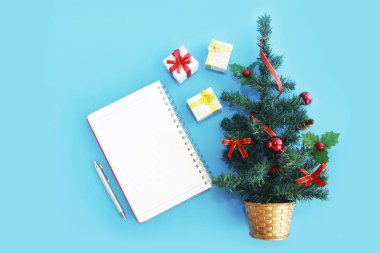 Notlar için not defteri ve yeni yıl dekorlu yeşil bir Noel ağacı.