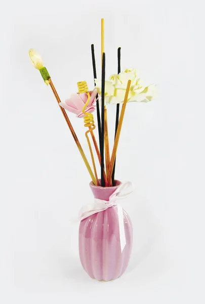 Palos de aromaterapia y flores artificiales decorativas en jarrón de cerámica rosa — Foto de Stock