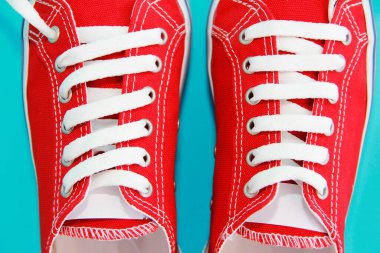 Beyaz bağcıklı kırmızı spor ayakkabılar.