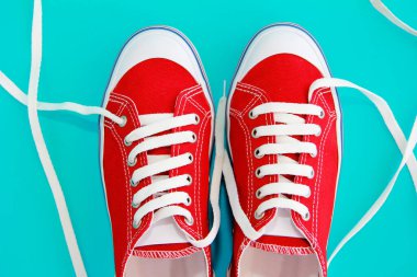 Beyaz bağcıklı kırmızı spor ayakkabılar.