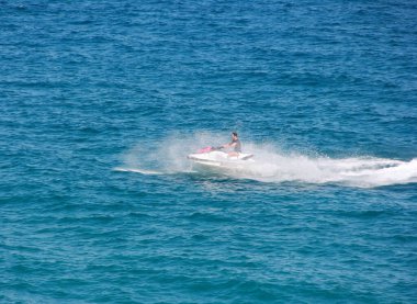 Antalya, Türkiye, 25 Mayıs 2020. İnsanlar mavi denizin dalgalarında jet ski kullanıyor.