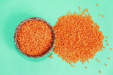 Yeşil arka planda doğal kırmızı mercimek taneleri