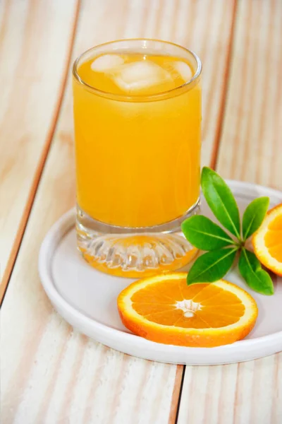 orange drink in glass and slices of natural orange
