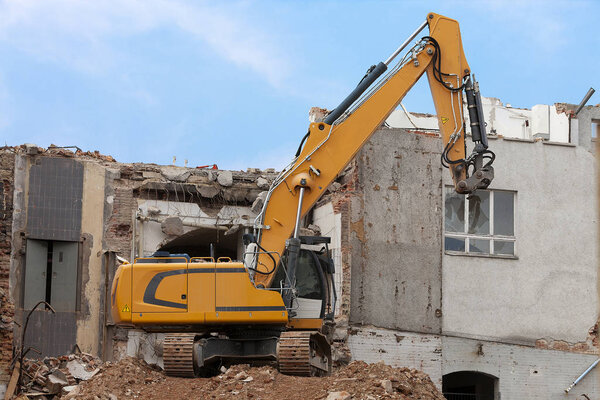 Excavator storms old house