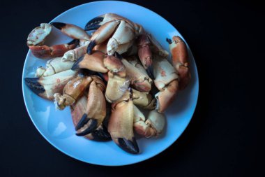 Atlantic Coast içinde belgili tanımlık siyah geçmiş bir tabakta gelen yengeç pençeleri