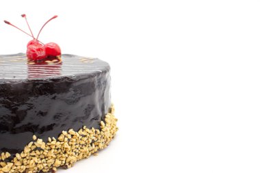 Lezzetli çikolatalı kek kiraz ve gevrek fındık, izole bir beyaz zemin üzerine dekore edilmiştir. Kopyalama alanı alanı ile pasta.