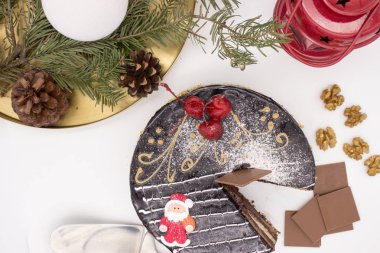 Lezzetli çikolatalı kek, dekore edilmiş kiraz ve şeker Noel Baba ve Noel dekor ve süs eşyaları ile çıtır kuruyemiş.