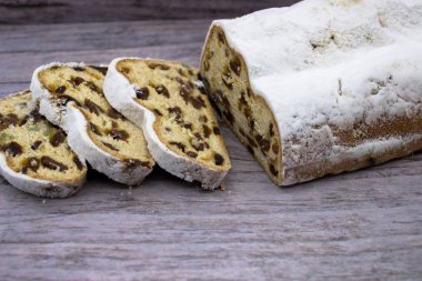 Üç dilim ve Stollen ana bölümü ahşap arka plan üzerinde. Geleneksel Alman Noel kek badem ezmesi ve Kuruyemiş.
